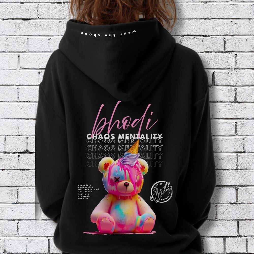 Black hoodie with colorful bear graphic and text on the back, worn by a person against a white brick wall.