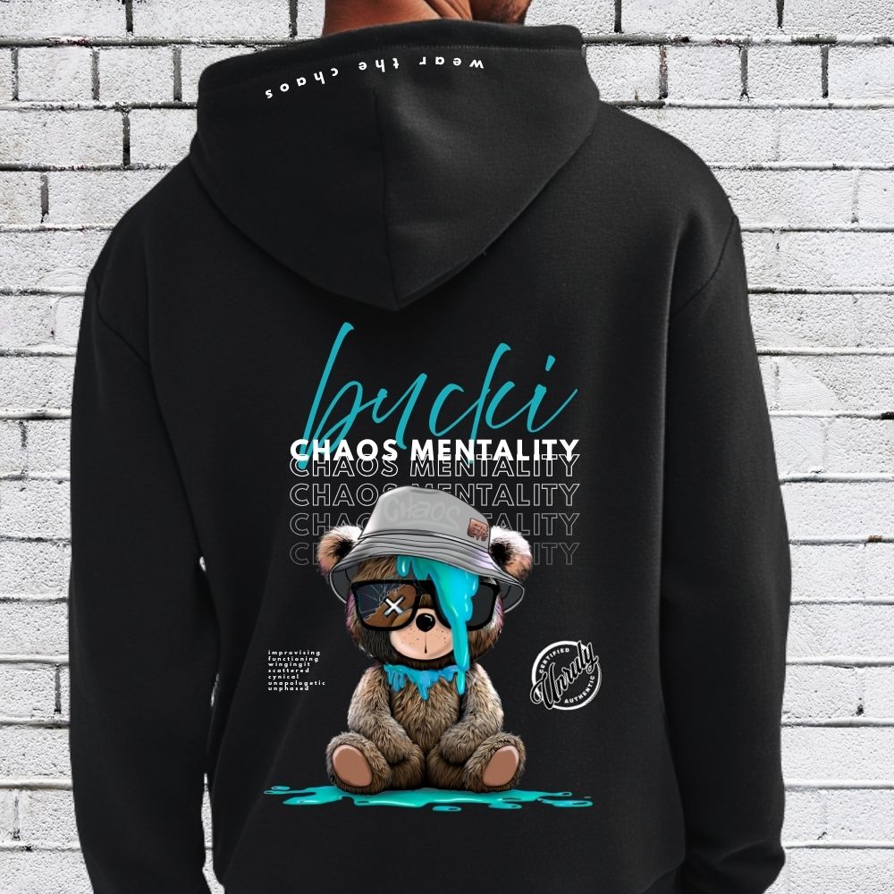Black hoodie with a bear graphic and text on the back against a white brick wall.