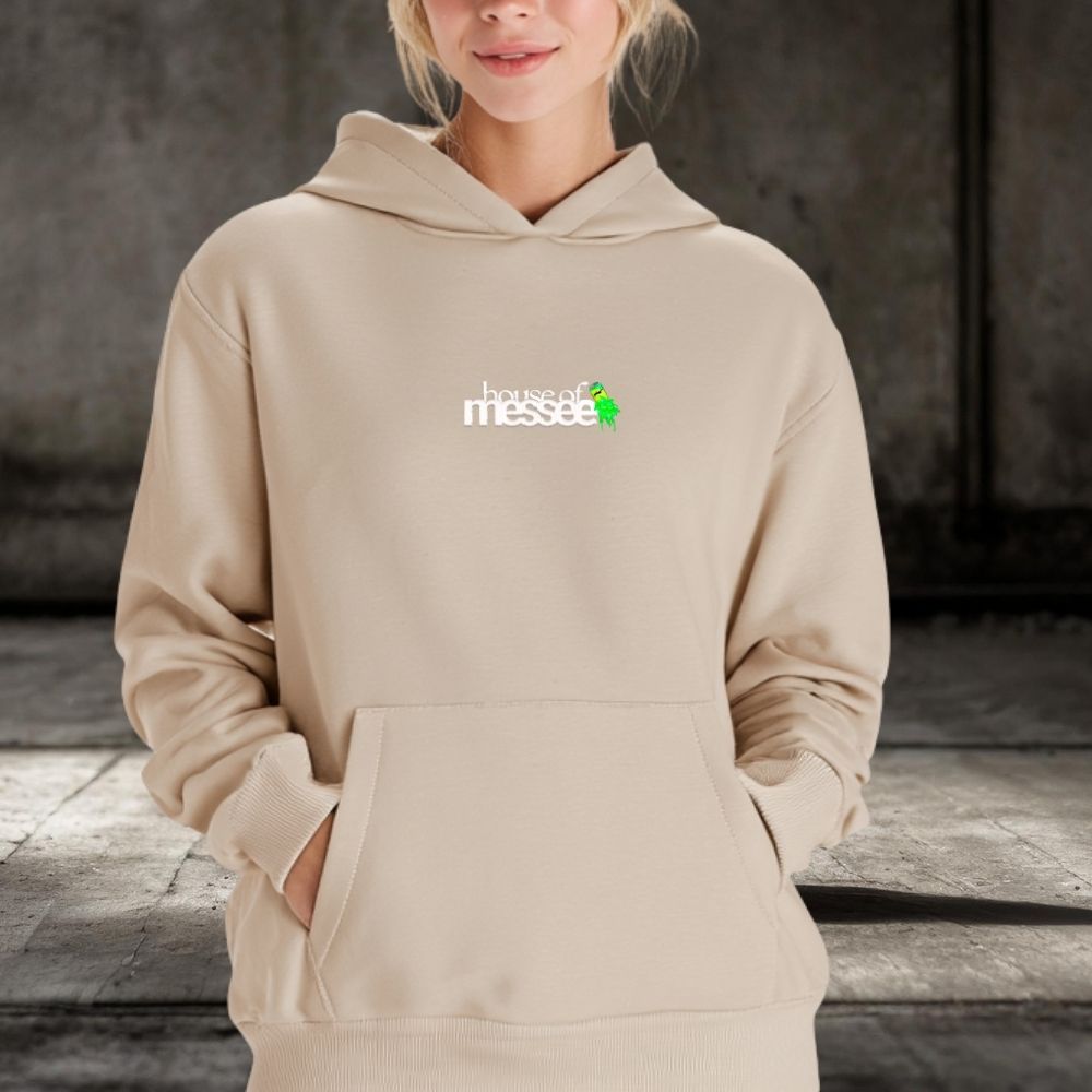 Person wearing a beige hoodie with a logo on a neutral background